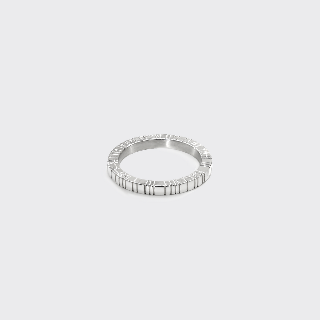 Silver ring with a beaded design on a light gray background