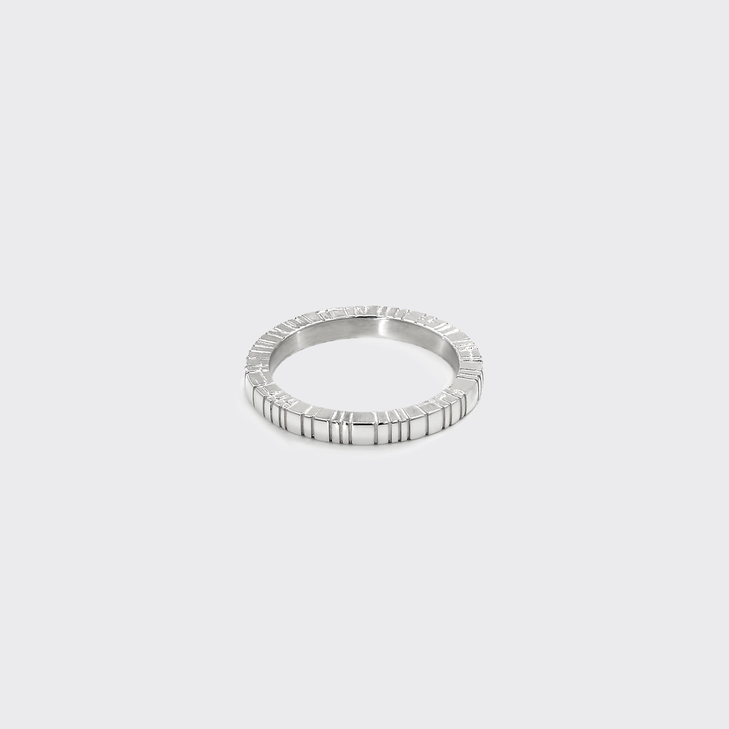 Silver ring with a beaded design on a light gray background