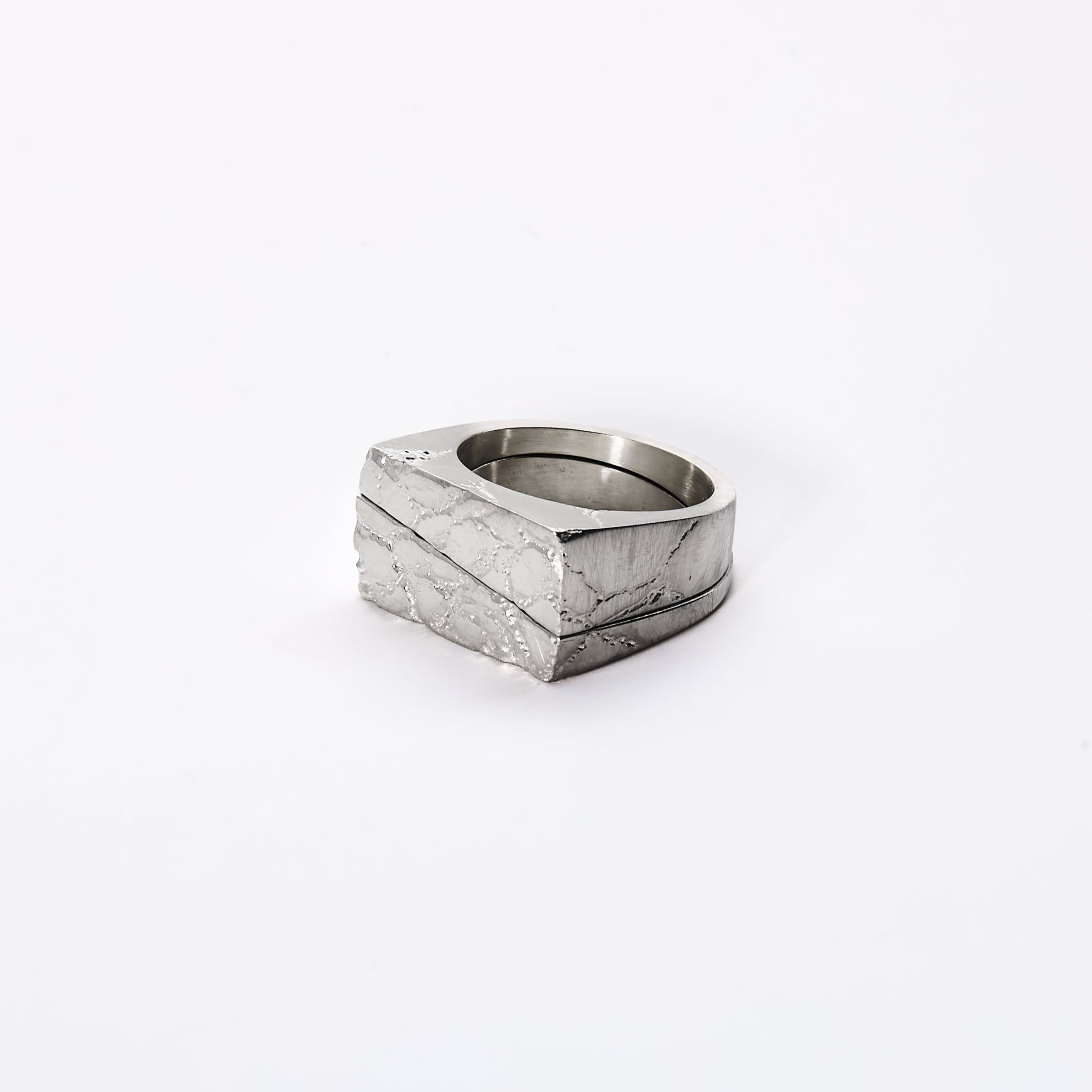 Silver ring with a textured design on a white background