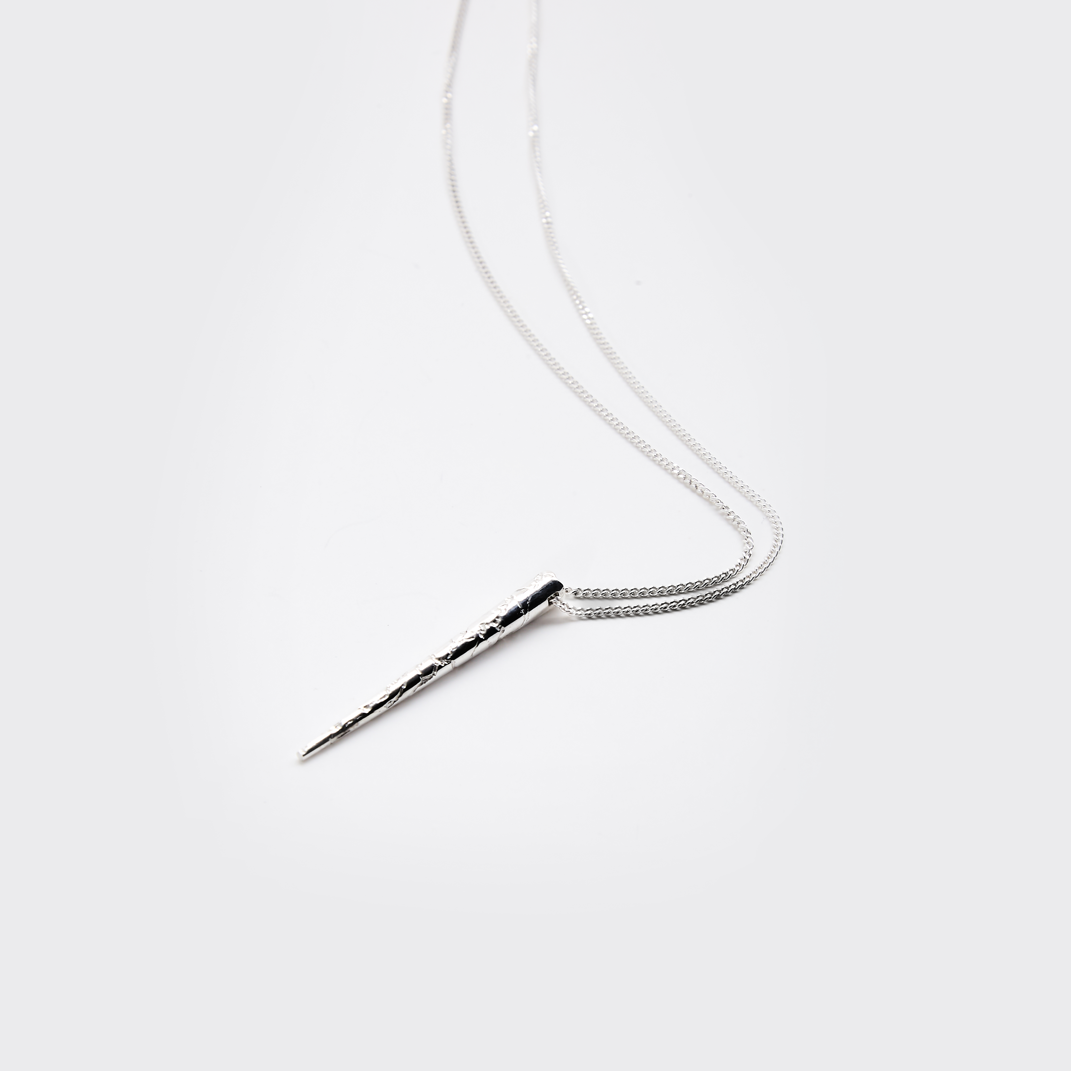 Silver necklace with a unique pendant on a white background